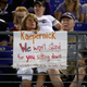 A fan sits behind a sign referring to former San Francisco 49ers quarterback Colin Kaepernick in the second half of the Washington Redskins and Baltimore Ravens preseason game on Aug. 10, 2017, in Baltimore. (Rob Carr/Getty Images)